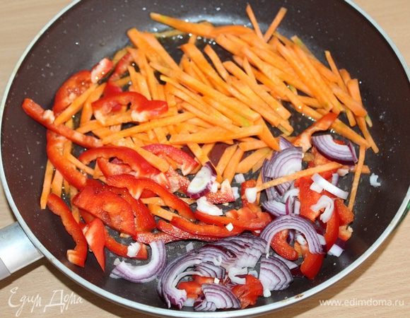 Затем слегка обжарить порезанные соломкой: морковь, перец и лук. Всыпать туда острый перец. Прогреть перец и перемешать с овощами.