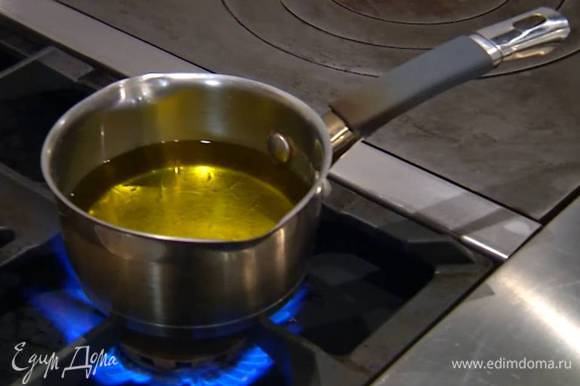 Оливковое масло прогреть в небольшой кастрюле, не доводя до кипения.