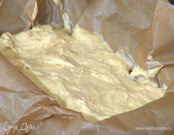 Продолговатую форму выстелить бумагой для выпечки, выложить тесто и разровнять его.