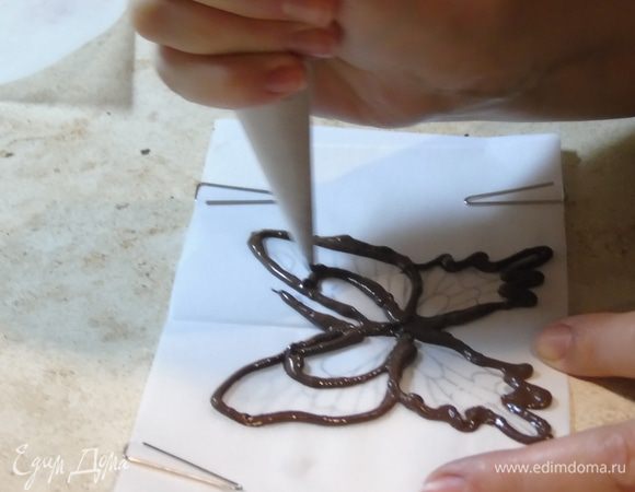 Шоколад растапливаем. Из пергамента делаем трубочку, кончик срезаем и наносим шоколад по контуру. Я это делала впервые поэтому не судите строго.