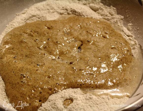 Вливаем оставшуюся воду, масло, закваску и замешиваем тесто.