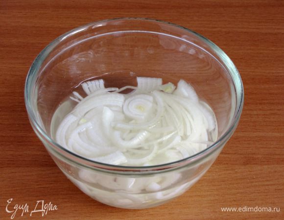 Первым делом замаринуем лук. В холодной кипяченой или бутилированной воде растворить сахар и соль, добавить уксус, перемешать. Лук нарезать тонкими полукольцами и оставить в этом маринаде на 20 минут.