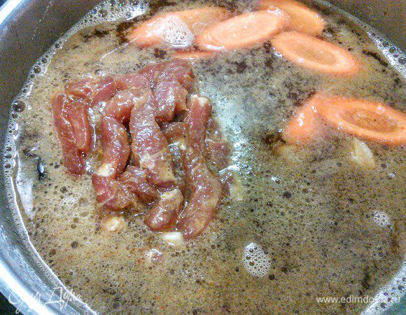 Куриный бульон довести до кипения, заправить соевым соусом, солью, перцем, уксусом и острым чили-соусом. Добавить грибы и мясо, довести до кипения. За это время мясо доходит до готовности, т. к. оно очень тонко порезано. 