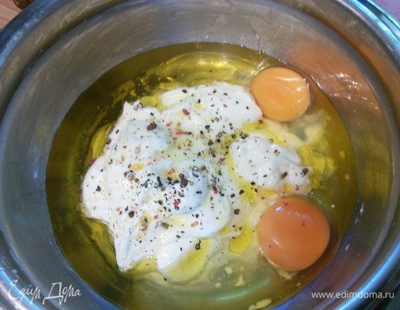 Яйца, йогурт, масло, соль, перец, чеснок и зелень соединить в миске и взбить венчиком.