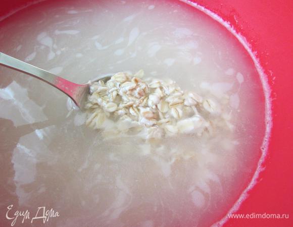 Приготовить овсяное молоко. В миску положить овсяные хлопья, залить холодной кипяченой водой и оставить на 8-12 часов при комнатной температуре.