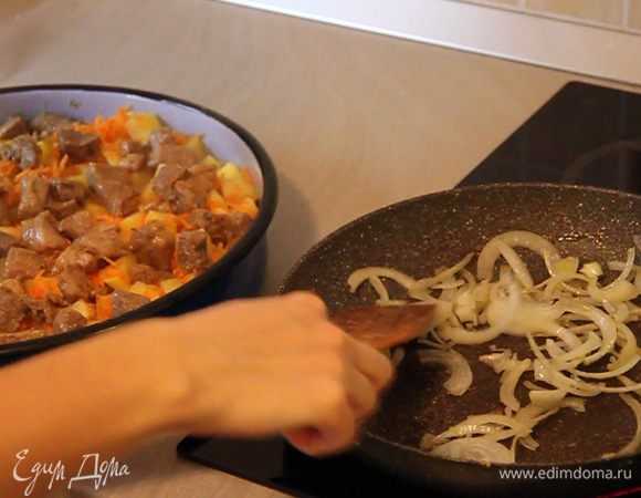 Немного обжариваем порезанную полукольцами одну луковицу. Выкладываем лук на мясо.