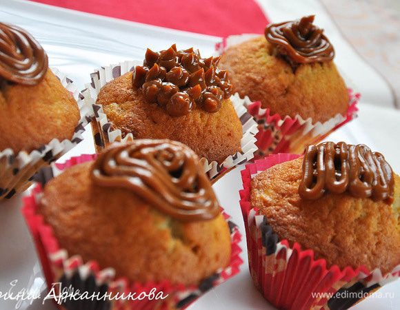 В остывших кексах сделать углубления. Можно маленькой кофейной ложечкой или спец. приспособлением. Положить в кексы сгущенку и украсить верхушки.