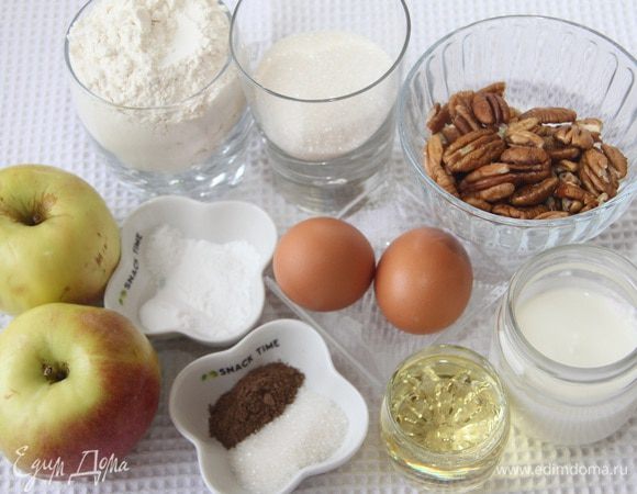 Понадобятся 2 яблока, 250 г муки, 100 г сахара, 2 ч.л. разрыхлителя, 1/2 ч. л. соды, 1/2 ч. л. соли, 100 г йогурта, 60 мл растительного масла, щепотка ванилина, 2 яйца, а также 50 г орехов (пекан или грецких), для сахарной коричной корочки 1 ст.л. сахара и 1 ч.л. корицы.
