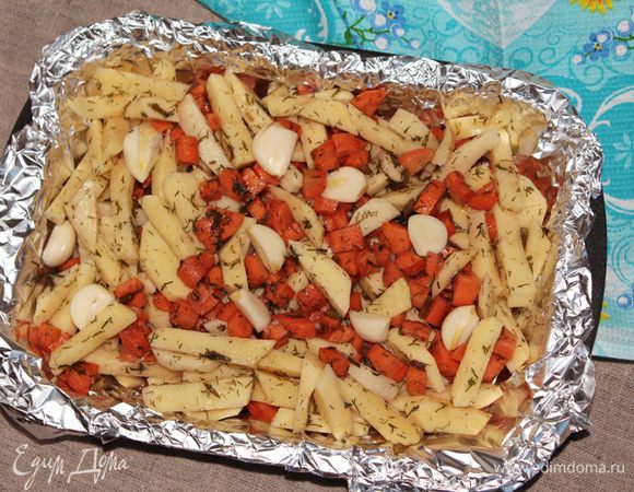 Жаростойкую форму для выпекания выстелить фольгой для запекания, чтобы овощи не пригорели и сохранился маринад. Выложить овощи и сверху выложить чеснок (9-10 небольших зубков, если очень крупный то порезать на 2-4 части).