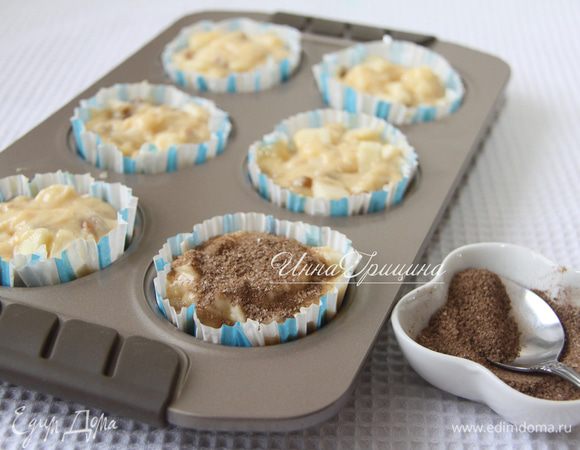 Тесто выложить в форму для маффинов. Удобно использовать бумажные вкладыши, чтобы не смазывать формочки маслом. Смешать сахар с корицей. Посыпать смесью каждый маффин.