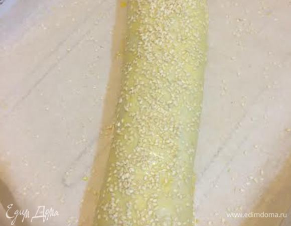 Смешать 1 желток, 2 ст.л молока и смазать рулет. Присыпать кунжутом. Выпекать в заранее разогретой духовке до 200°C 40-50 минут.