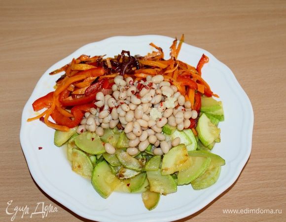 Горячие овощи выложить вместе с маслом на тарелочку, добавить фасоль. Посыпать мелко нашинкованным чесноком и перемешать. 