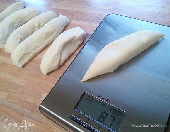 Затем тесто разделить на 6 частей по примерно 90 граммов. Каждую часть скрутить двумя руками, катая их по столу, в жгуты с толстой средней частью и утончающимися концами с обеих сторон. Жгуты должны быть 50 — 60 см длиной. Оставить на отдых на 10 мин. За это время проделать то же самое с остальными частями теста. 