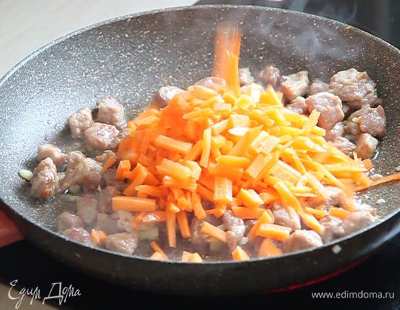 Открываем крышку, перемешиваем мясо с луком, доливаем растительное масло из нашего стаканчика и выкладываем нарезанную соломкой морковь.