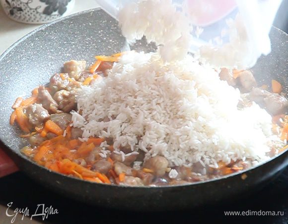 Через пару минут открываем крышку, перемешиваем морковь. Вливаем остаток растительного масла из нашего стаканчика и добавляем промытый после отстаивания рис.
