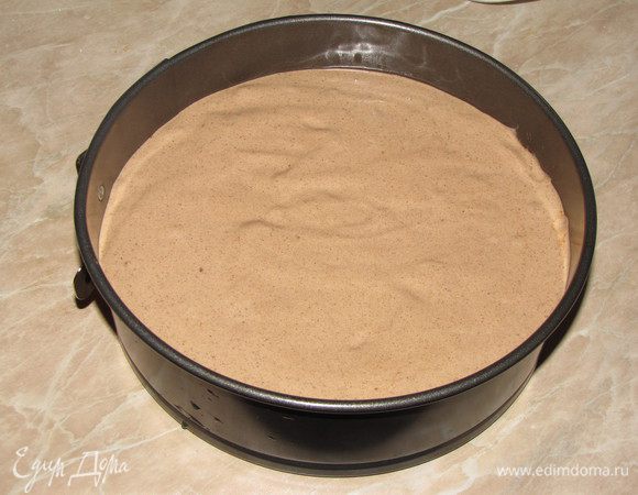 Форму диаметром 20 см, застелить пекарской бумагой, вырезав по форме круг. Смазать бумагу сливочным маслом, бортики смазывать не нужно. Вылить тесто. Немного прокрутить форму вокруг своей оси, чтобы тесто легло ровнее.