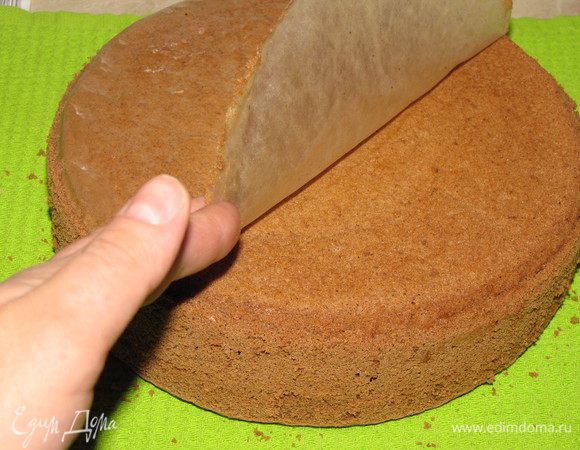 Немного остывший бисквит перевернуть на полотенце, снять пекарскую бумагу.