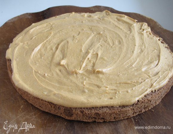 Выложить первый корж и смазать его кремом. 