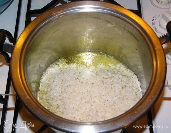 Берем кастрюльку с толстым дном или другую посуду, в которой вы обычно готовите рис. Добавляем растительное и сливочное масло. Сцеживаем рис и отваренный артишок. Слегка обжариваем рис в масле... 