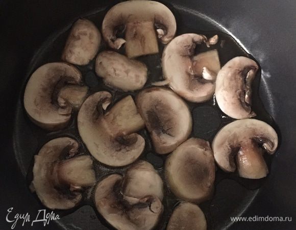Шампиньоны промываем, обрезаем низ ножки, режем на тонкие слайсы и обжариваем в сотейнике на оливковом масле с обеих сторон на среднем огне. В конце обжарки прибавляем огонь, чтобы грибы покрылись красивым румянцем. 