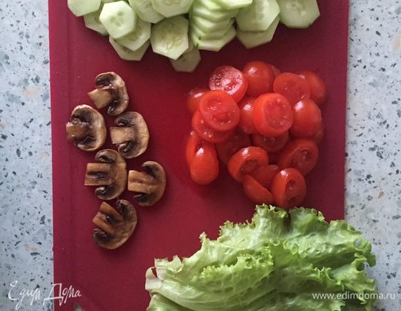 Огурец очищаем от кожуры и режем тонкими ломтиками, черри нарезаем на тонкие половинки или четвертинки, листья салата обмываем и обсушиваем на бумажном полотенце. 