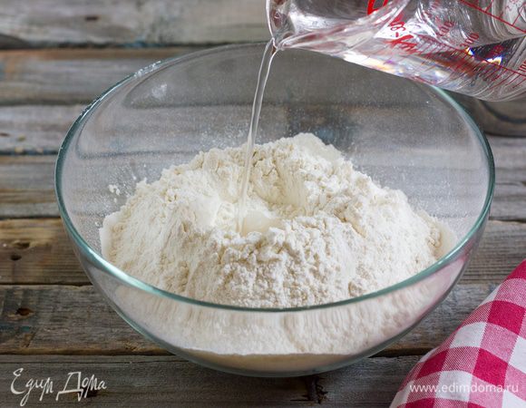 Постепенно вливайте в центр горки воду, затем добавьте масло.