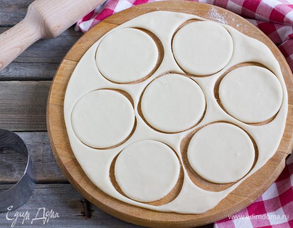 Тесто раскатайте на присыпанной мукой поверхности в пласт толщиной 2 мм. С помощью стакана или круглой кондитерской форму вырежьте кружочки из теста диаметром 6 см.