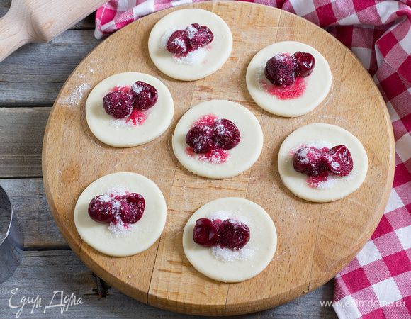 На каждый кружок выложить 2-3 вишенки и немного сахара.