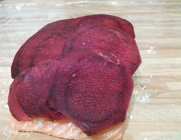 Бурячок среднего размера очистить, нарезать кружочками и выложить в нахлёст на рыбное филе. 