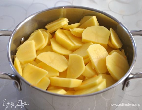 Затем слой картофеля, нарезанного на пластинки шириной 0,5 см.