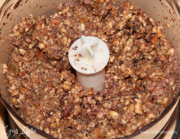 Сначала готовим основной корж: изюм и цукаты заливаем вишневым соком на 30 минут. Подсушенные на сковороде орехи смалываем в мелкую крошку. Затем добавляем изюм и цукаты (без сока) и смалываем все в блендере или пропускаем через мясорубку. Если нужно — добавляем немного сока, чтобы получилась вязкая масса.