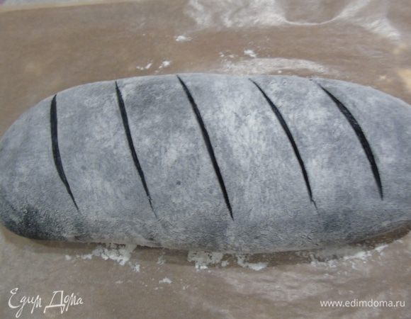 Делаем надрезы и отправляем в духовку, которую предварительно сбрызгните холодной водой. Через 5 минут, уменьшите температуру до 200°С, еще раз побрызгайте духовку и выпекайте хлеб еще 25-35 минут, ориентируйтесь по своей духовке. Затем переложите хлеб на решетку, и оставьте в выключенной духовке до остывания, слегка приоткрыв дверцу.
