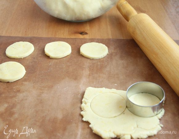 Раскатать тесто на коврике, вырезать формочкой печенье.