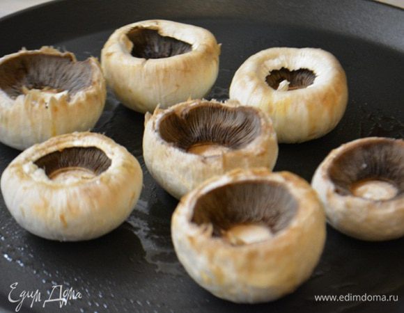 Сковороду накалить, сбрызнуть оливковым маслом и поджарить грибы с одной стороны. Жарить не больше 2 минут, чтобы грибы не пустили сок.