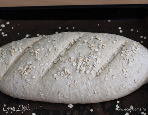 Накрыть плёнкой и поставить на расстойку на 1-1,5 часа. 
На хлебе сделать разрезы и выпекать его 10 минут с паром. затем сбавить температуру на 200°С, выпустить из духовки пар и выпекать хлеб до готовности минут 30.
