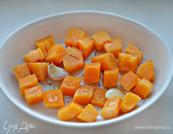Тыкву помыть, почистить и нарезать на небольшие кусочки. Уложить тыкву вместе с зубчиками чеснока (можно не чищенные) в форму для запекания, сбрызнуть оливковым маслом, посыпать розмарином и запекать при 180°C до готовности. У меня этот процесс занял 25 мин.