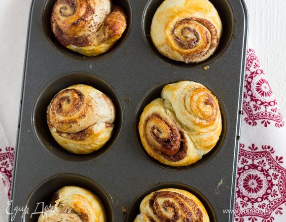 Противень смажьте оставшимся сливочным маслом, и переложите на противень кружки. Выпекайте булочки 15 минут, пока они не станут хрустящими и золотистыми. Подавайте теплыми.