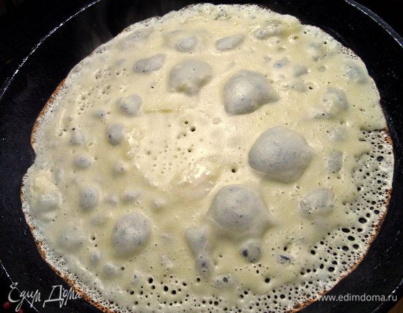 Смазываем маслом чугунную сковороду и наливаем тонкое блинное тесто.