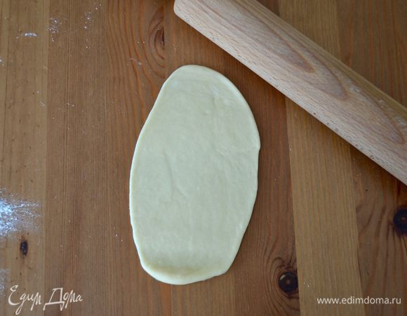 Через час тесто выложить на рабочую поверхность. Отделить от него кусочки теста весом по 50 г. У меня получается ровно 9 штук. Каждый кусочек раскатать в длинную лепешку (как на фото).
