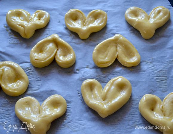 Выложить булочки на противень, застеленный пекарской бумагой. Накрыть полотенцем и оставить ещё на 15-20 минут. За это время включить разогреваться духовку на 175-180°C. Перед выпечкой смазать булочки яйцом.