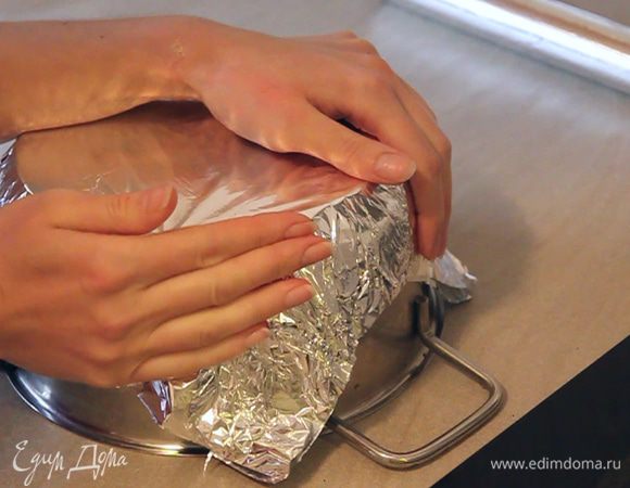 В самом начале мы должны подготовить две одинаковые по размеру формы. Подберите диаметр формы такой, чтобы две формы стали рядом одна с другой на один противень в духовку. Так как выпекать коржи мы будем одновременно.
Для приготовления формы нам понадобится кастрюля либо другая емкость, которую мы можем использовать как основу под форму. И, конечно же – фольга.
Берем кастрюлю, сверху прикладываем фольгу и отмеряем отрез так, чтоб фольга заходила на 8-10 см на стенки кастрюли. Отмеряем в сумме по 3 таких же отреза на каждую форму. Всего 6 отрезов. Три отреза фольги мы складываем вместе так, чтобы матовая сторона фольги была в середине формы. Это важно. Обминаем все три отреза для первой формы вокруг кастрюли. Нужно получить непрерывную по высоте стенку формы. Повторяем тоже самое для второй формы.
Смазываем формы растительным маслом и приступаем к приготовлению самого торта.