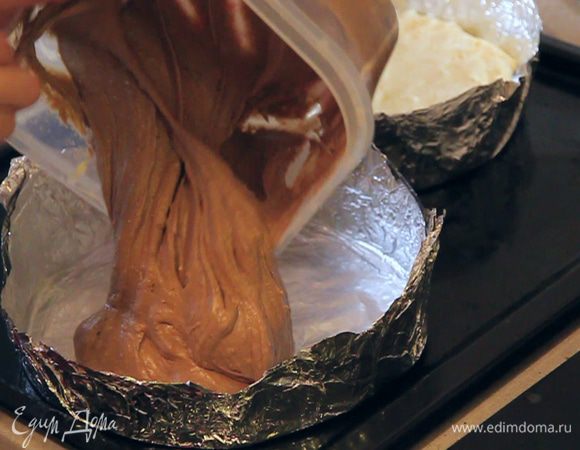 Выкладываем тесто для темных коржей так же в форму, которая уже стоит на противне. Тоже разравниваем его сверху смоченными в воде руками. Желательно обе формы сразу разместить на противне, чтоб наше тесто уже не деформировалось при перемещении форм.