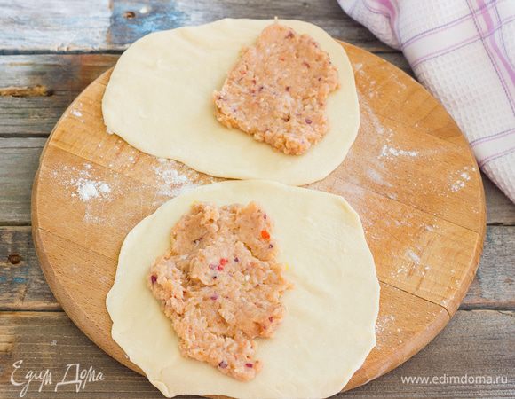 Разделите тесто на 10–15 частей и раскатайте их на присыпанной мукой поверхности в круги диаметром 10 см, толщиной 2 мм. Выложите 1 ст.л. фарша и разровняйте его по одной половине лепешки, и накройте второй половиной. 