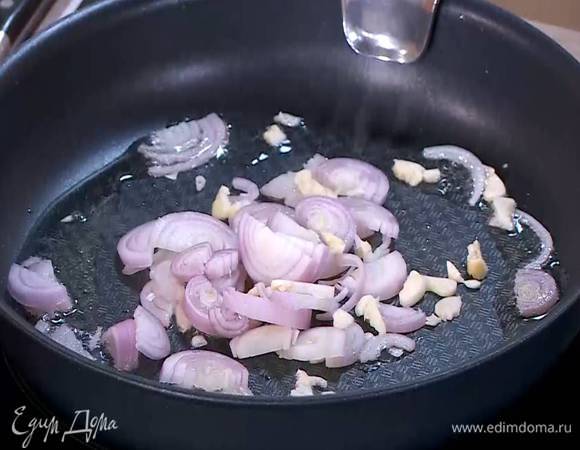 Разогреть в сковороде со съемной ручкой немного оливкового масла и обжарить лук с чесноком.