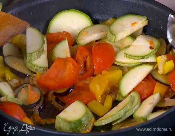 В сковороду с овощами добавить помидор и кабачок, слегка посолить, перемешать и все обжарить.