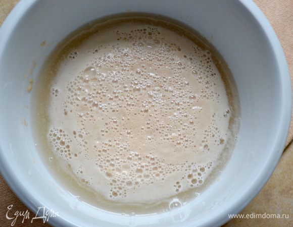 В теплой (37-38ºC) воде развести сахар и дрожжи. Слегка размешать и дать дрожжам активизироваться (10-15 минут).