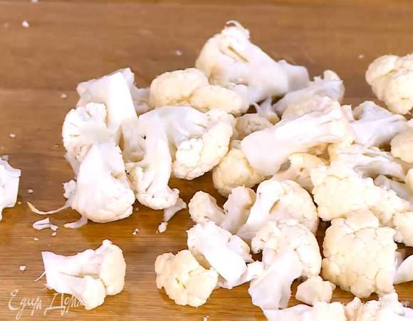 Цветную капусту разобрать на небольшие соцветия и, срезав грубые стебли, выложить в глубокую посуду.