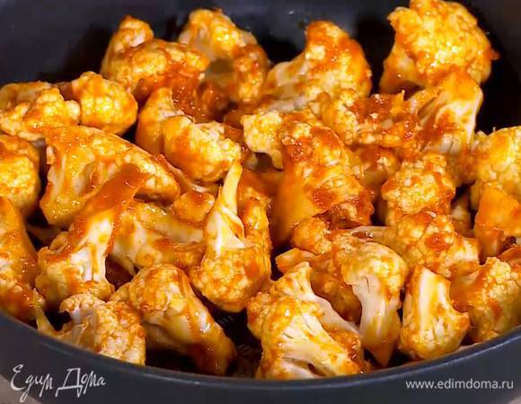 Заправленную капусту выложить в небольшой противень и запекать под разогретым грилем 5 минут.