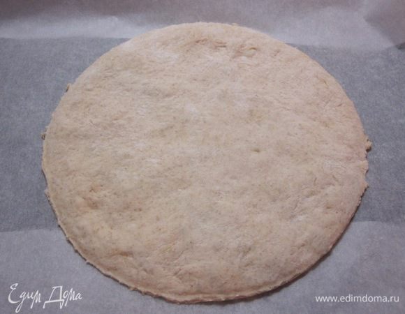 Тесто разделить на 2 равные части. Одну часть раскатать в круг диаметром 25 см, выложить на противень, выстланный бумагой для выпечки.