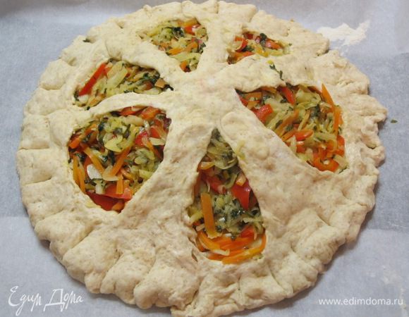 Вторую часть теста раскатать в круг чуть большего диаметра, вырезать 6 лепестков, накрыть начинку. Руками прижать края, сделать по краю надрезы.